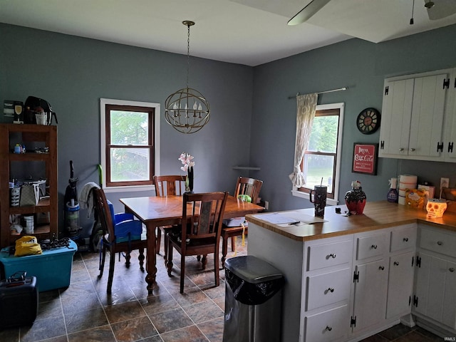 622 S Market St, Winamac, IN 46996 - kitchen with a peninsula, white cabinets, a chandelier, pendant lighting, and dark stone finish floors