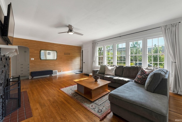4230 Tacoma Ave, Fort Wayne, IN 46807 - living room featuring ceiling fan, wooden walls, wood finished floors, and a fireplace
