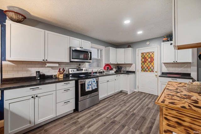 919 S 18th St, Lafayette, IN 47905 - kitchen with appliances with stainless steel finishes, white cabinetry, decorative backsplash, dark wood-style floors, and recessed lighting