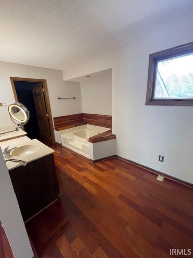 7030 Windshire Dr, Fort Wayne, IN 46814 - bathroom with vanity, a garden tub, and wood finished floors