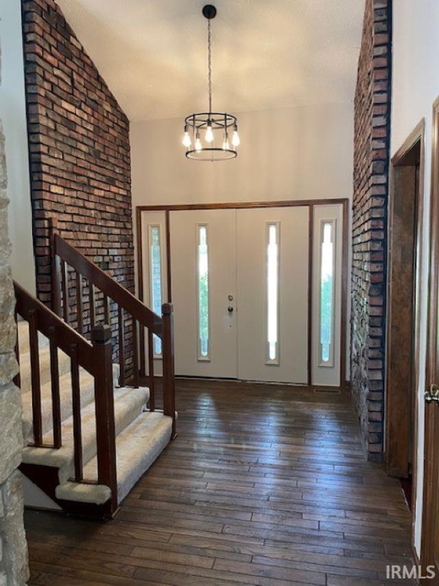 7030 Windshire Dr, Fort Wayne, IN 46814 - foyer entrance featuring wood-type flooring, a chandelier, stairs, and high vaulted ceiling