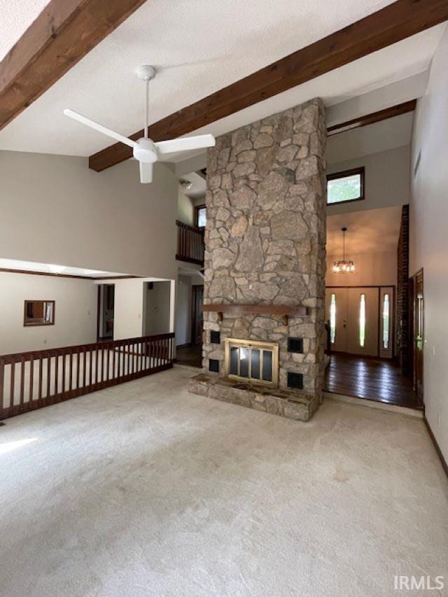 7030 Windshire Dr, Fort Wayne, IN 46814 - unfurnished living room featuring a towering ceiling, a ceiling fan, carpet, a stone fireplace, and beam ceiling