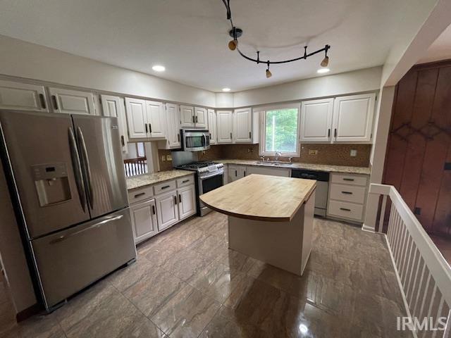 7030 Windshire Dr, Fort Wayne, IN 46814 - kitchen with appliances with stainless steel finishes, decorative backsplash, white cabinetry, recessed lighting, and butcher block counters