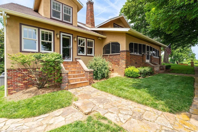 209 S 2nd St, Rockport, IN 47635 - view of front of property with stucco siding, a front lawn, a chimney, and brick siding