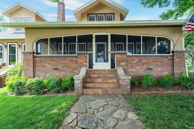 209 S 2nd St, Rockport, IN 47635 - view of front of property with entry steps, brick siding, stucco siding, a sunroom, and a chimney