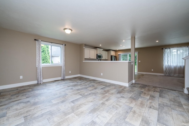 305 Hill Top Ct, New Carlisle, IN 46552 - unfurnished living room with healthy amount of natural light, light wood finished floors, and recessed lighting