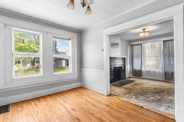906 S Union St, Kokomo, IN 46901 - unfurnished living room with hardwood / wood-style floors, a wainscoted wall, a fireplace, and ornamental molding
