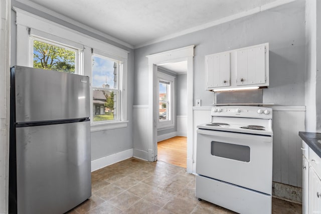 906 S Union St, Kokomo, IN 46901 - kitchen featuring freestanding refrigerator, white range with electric cooktop, plenty of natural light, white cabinetry, and ornamental molding