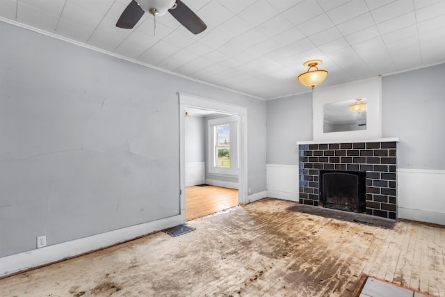 906 S Union St, Kokomo, IN 46901 - unfurnished living room featuring crown molding, a tile fireplace, a ceiling fan, and hardwood / wood-style flooring