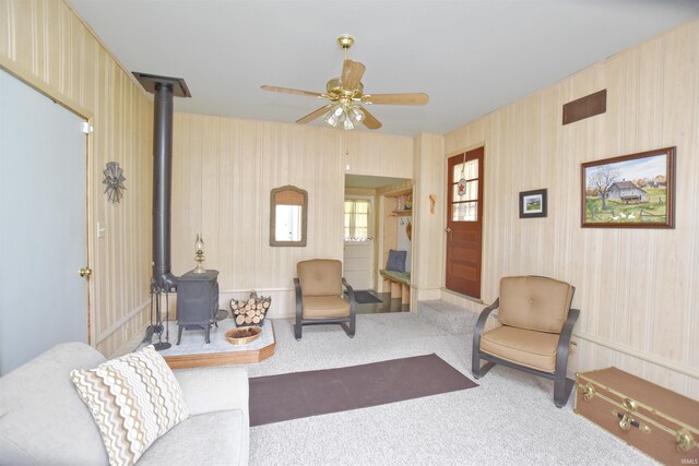 2885 E Bradford Ct, Monon, IN 47959 - living area with a wood stove, carpet flooring, and ceiling fan