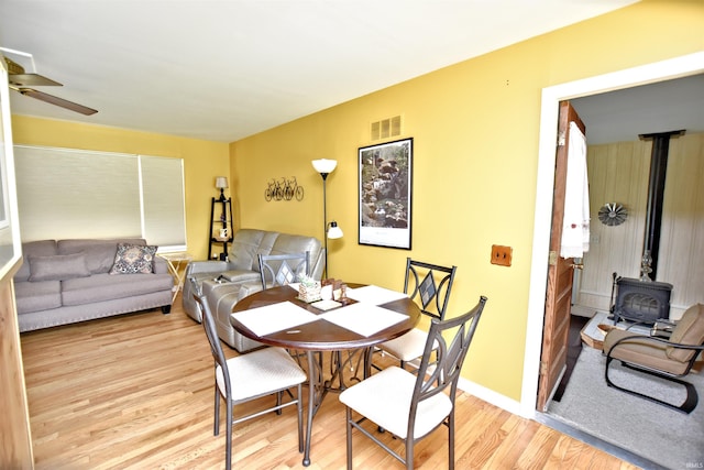 2885 E Bradford Ct, Monon, IN 47959 - dining room with a wood stove, light wood-style floors, and a ceiling fan