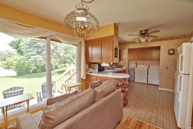2885 E Bradford Ct, Monon, IN 47959 - kitchen with washer and clothes dryer, freestanding refrigerator, light countertops, a ceiling fan, and a peninsula