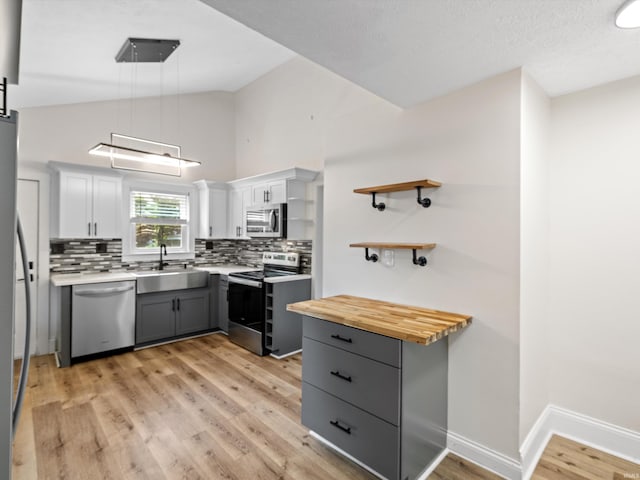 2015 E Blackford Ave, Evansville, IN 47714 - kitchen with stainless steel appliances, gray cabinetry, tasteful backsplash, open shelves, and light wood-type flooring