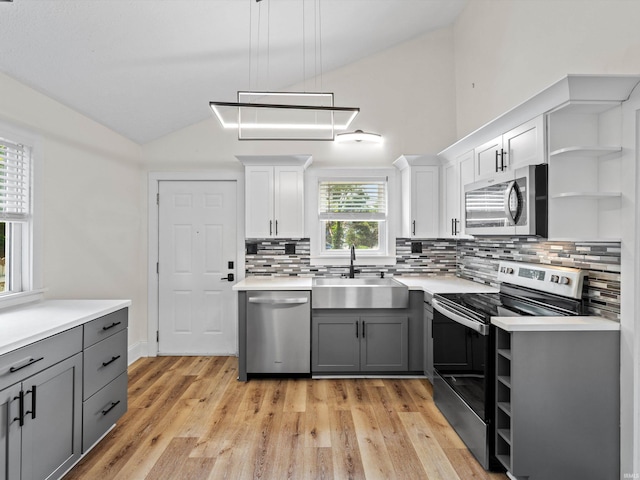 2015 E Blackford Ave, Evansville, IN 47714 - kitchen with appliances with stainless steel finishes, open shelves, vaulted ceiling, gray cabinets, and tasteful backsplash