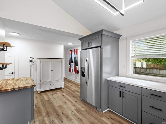 2015 E Blackford Ave, Evansville, IN 47714 - kitchen featuring stainless steel refrigerator with ice dispenser, gray cabinets, butcher block counters, light wood-type flooring, and lofted ceiling