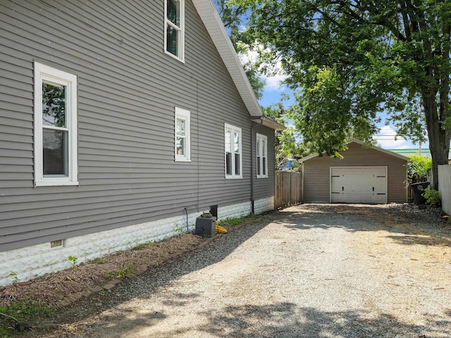 2015 E Blackford Ave, Evansville, IN 47714 - view of side of home with an outdoor structure, a detached garage, dirt driveway, and crawl space