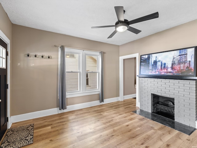 2015 E Blackford Ave, Evansville, IN 47714 - unfurnished living room featuring light wood-type flooring, ceiling fan, a textured ceiling, and a brick fireplace