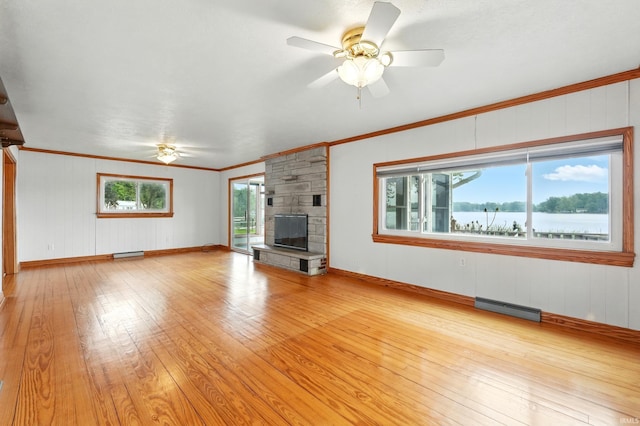 1385 S 460 E, Lagrange, IN 46761 - unfurnished living room with a ceiling fan, light wood-style flooring, crown molding, a stone fireplace, and wooden walls