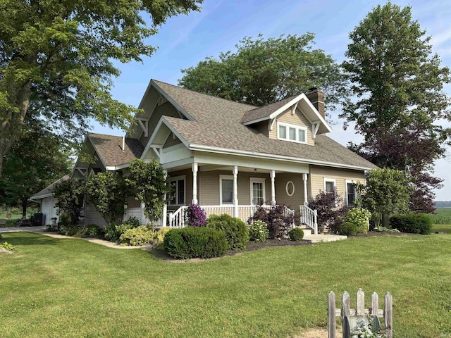 7614 N 100 W Rd, Uniondale, IN 46791 - view of front facade with a chimney, a shingled roof, a front yard, and a porch