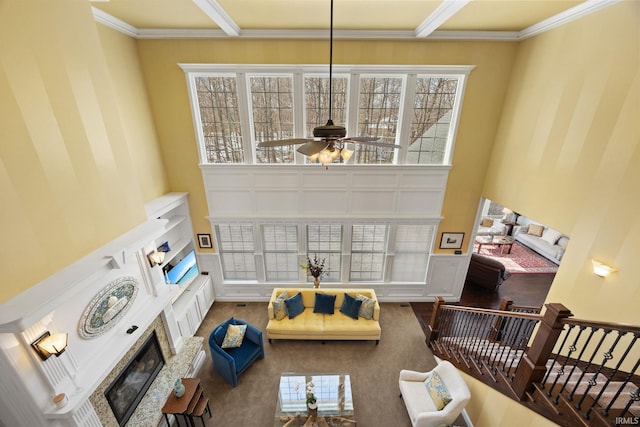 1130 Kingswood Rd, West Lafayette, IN 47906 - living room with a glass covered fireplace, a ceiling fan, a high ceiling, and ornamental molding