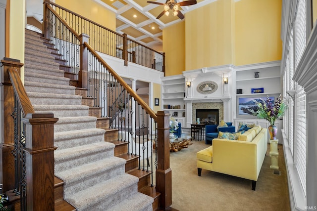 1130 Kingswood Rd, West Lafayette, IN 47906 - stairs featuring a fireplace, ceiling fan, crown molding, a towering ceiling, and coffered ceiling