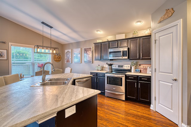 2407 Ellington Ridge Dr, Evansville, IN 47711 - kitchen with appliances with stainless steel finishes, vaulted ceiling, dark brown cabinets, dark wood-style flooring, and light countertops