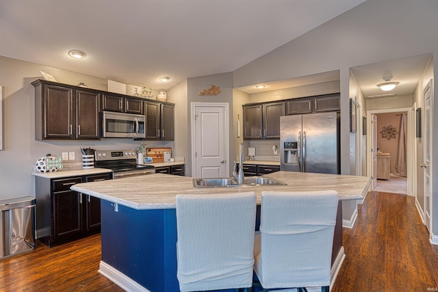 2407 Ellington Ridge Dr, Evansville, IN 47711 - kitchen with stainless steel appliances, vaulted ceiling, light countertops, dark brown cabinets, and dark wood-type flooring