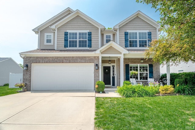 297 Indigo St, Lafayette, IN 47909 - craftsman-style home featuring a front yard, driveway, an attached garage, brick siding, and covered porch