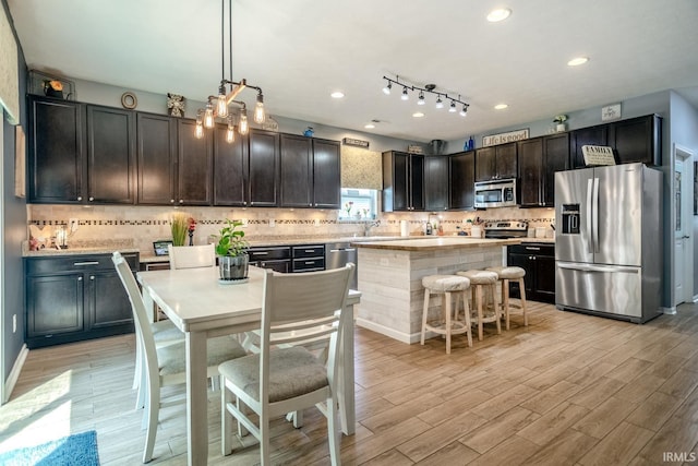 297 Indigo St, Lafayette, IN 47909 - kitchen with stainless steel appliances, light countertops, light wood-type flooring, tasteful backsplash, and recessed lighting