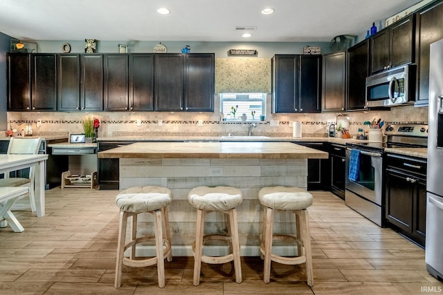 297 Indigo St, Lafayette, IN 47909 - kitchen with stainless steel appliances, a breakfast bar, a center island, backsplash, and recessed lighting