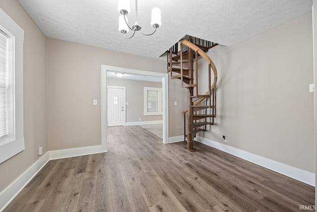 621 S 28th St, Lafayette, IN 47904 - unfurnished dining area featuring stairs, wood finished floors, a textured ceiling, and a chandelier