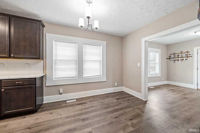 621 S 28th St, Lafayette, IN 47904 - unfurnished dining area with light wood finished floors, a textured ceiling, and a chandelier
