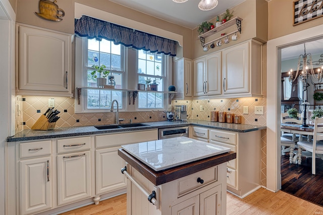 2732 Pennsylvania St, Evansville, IN 47712 - kitchen featuring a chandelier, light wood finished floors, white cabinets, and backsplash