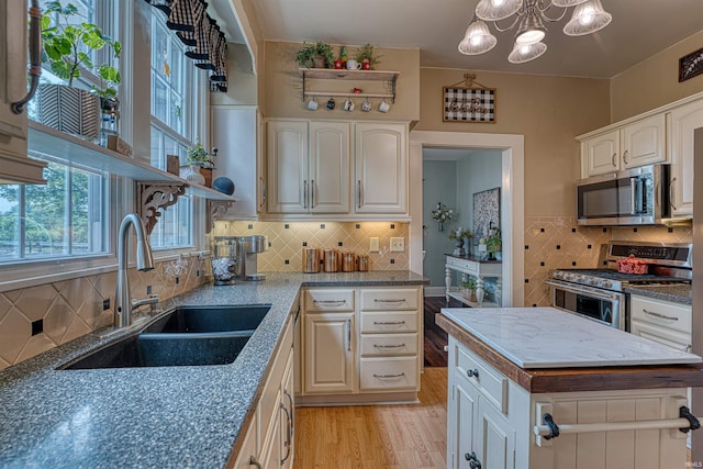 2732 Pennsylvania St, Evansville, IN 47712 - kitchen featuring stainless steel appliances, light wood-type flooring, backsplash, a chandelier, and white cabinets
