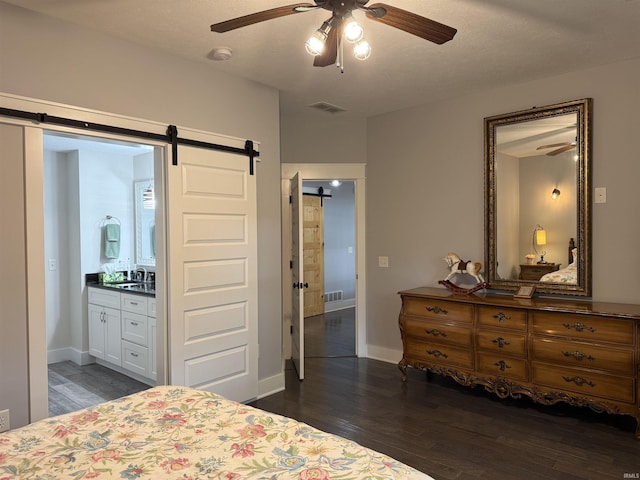 1285 E Zinnia Dr, Bloomington, IN 47401 - bedroom featuring a barn door, dark wood-style floors, ensuite bath, and a ceiling fan