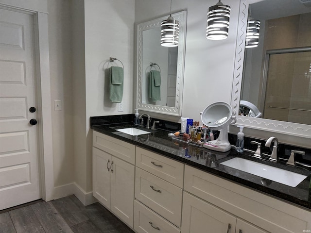 1285 E Zinnia Dr, Bloomington, IN 47401 - full bathroom featuring double vanity, a tile shower, and wood finished floors