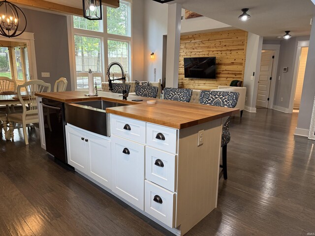 1285 E Zinnia Dr, Bloomington, IN 47401 - kitchen featuring wood counters, dishwasher, open floor plan, a kitchen island with sink, and wooden walls