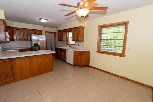 18655 Cleveland Rd, South Bend, IN 46637 - kitchen featuring white appliances, light countertops, a peninsula, ceiling fan, and plenty of natural light