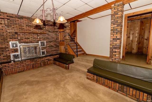 18655 Cleveland Rd, South Bend, IN 46637 - living area with carpet, brick wall, stairs, and a paneled ceiling