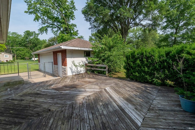 18655 Cleveland Rd, South Bend, IN 46637 - wooden deck featuring a detached garage, an outbuilding, and a gate