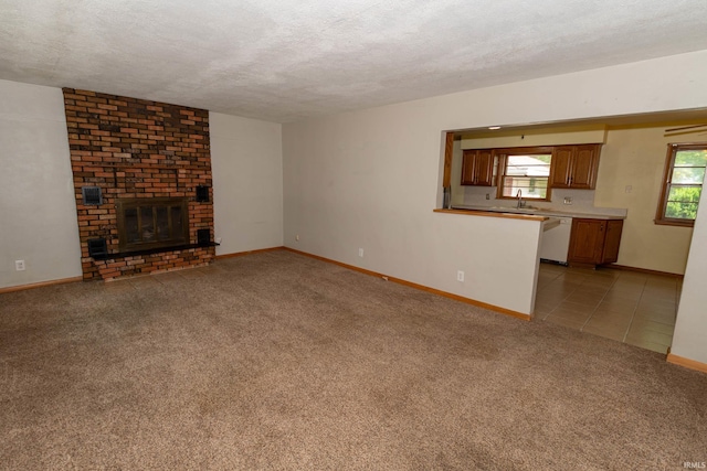 18655 Cleveland Rd, South Bend, IN 46637 - unfurnished living room with light carpet, a textured ceiling, a brick fireplace, and light tile patterned floors