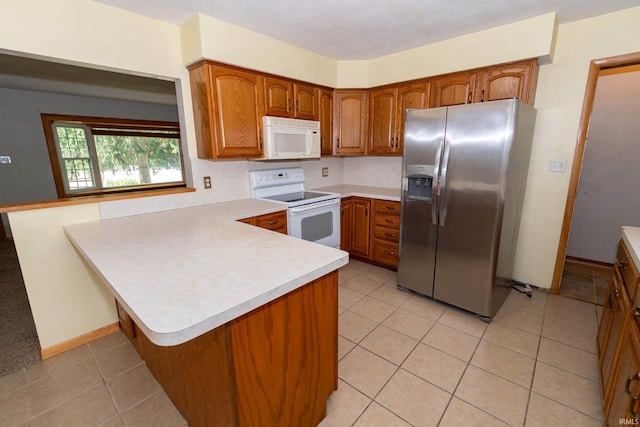 18655 Cleveland Rd, South Bend, IN 46637 - kitchen with white appliances, a peninsula, brown cabinets, and light countertops