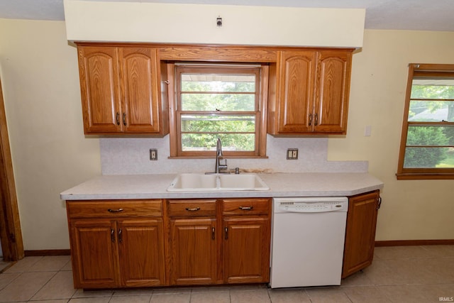 18655 Cleveland Rd, South Bend, IN 46637 - kitchen with white dishwasher, brown cabinetry, light countertops, and tasteful backsplash