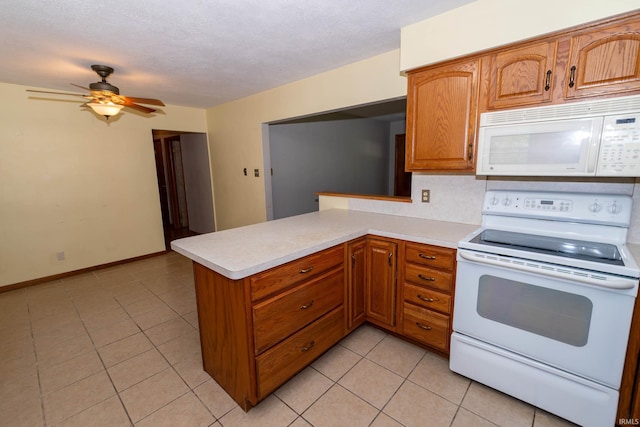 18655 Cleveland Rd, South Bend, IN 46637 - kitchen with white appliances, light countertops, light tile patterned floors, a peninsula, and a textured ceiling