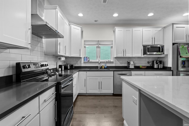 1014 Happy Hollow Rd, West Lafayette, IN 47906 - kitchen featuring stainless steel appliances, wall chimney exhaust hood, white cabinets, recessed lighting, and backsplash