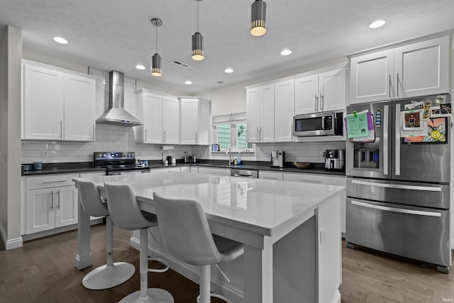1014 Happy Hollow Rd, West Lafayette, IN 47906 - kitchen with appliances with stainless steel finishes, wall chimney range hood, dark wood-style floors, backsplash, and white cabinets