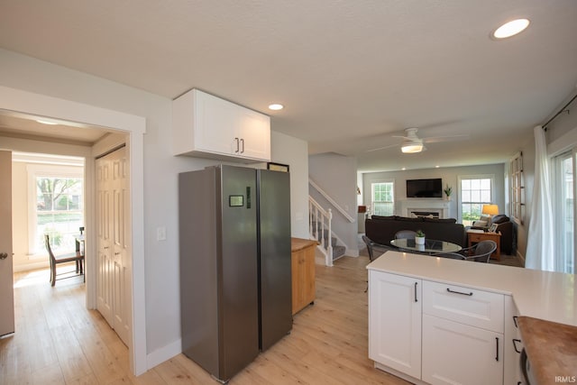1914 Bayberry Ln, West Lafayette, IN 47906 - kitchen featuring freestanding refrigerator, a fireplace, white cabinetry, light wood-style floors, and ceiling fan