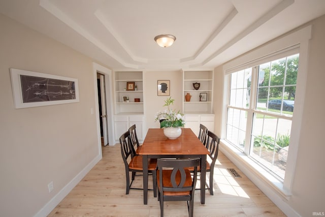 1914 Bayberry Ln, West Lafayette, IN 47906 - dining room with built in shelves, a tray ceiling, and light wood-type flooring