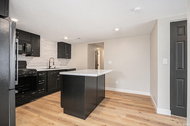 822 W Donaldson Ave, Mishawaka, IN 46545 - kitchen featuring black appliances, dark cabinets, light countertops, a center island, and tasteful backsplash