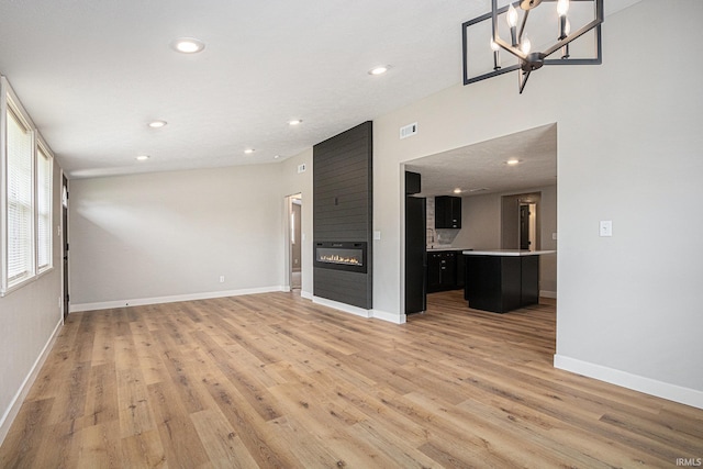 822 W Donaldson Ave, Mishawaka, IN 46545 - unfurnished living room featuring light wood-style floors, recessed lighting, a fireplace, and a chandelier
